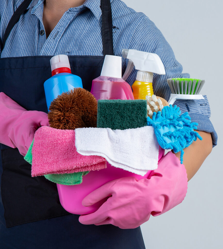 a person holding a bucket of cleaning supplies